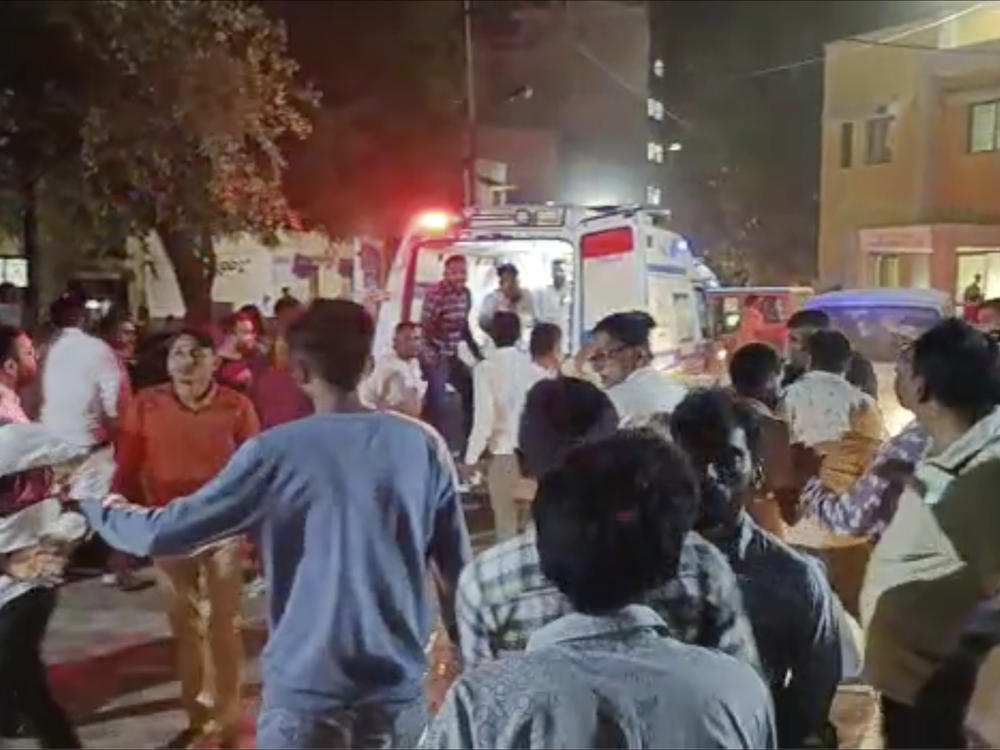 This image from video shows the commotion outside a hospital where victims of a cable bridge collapse were being rushed in for treatment Sunday in Morbi district, western Gujarat state, India.