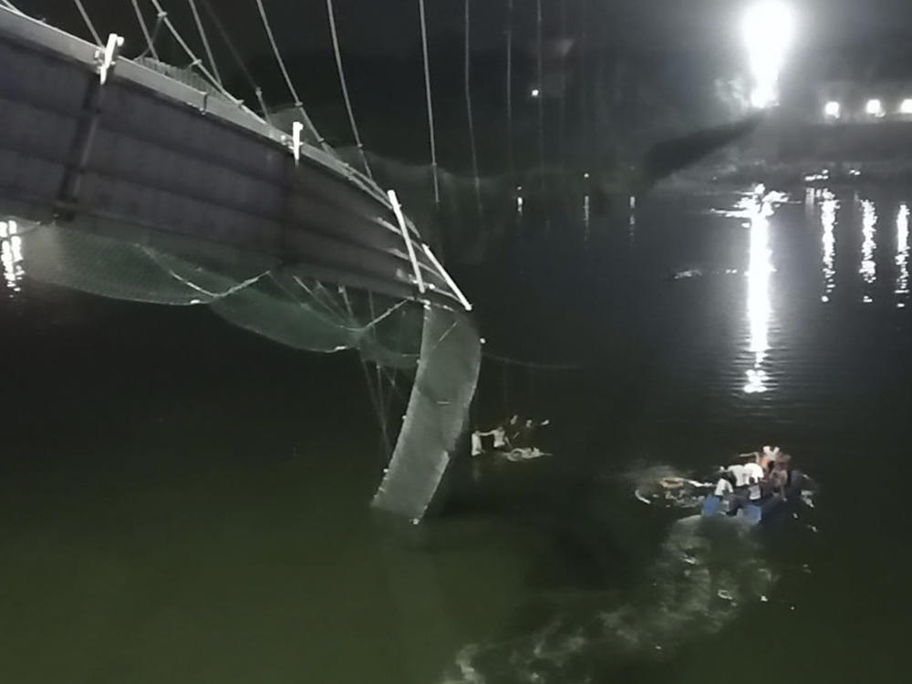 Rescuers on boats search in the Machchu river next to a cable bridge that collapsed in Morbi district, western Gujarat state, India.