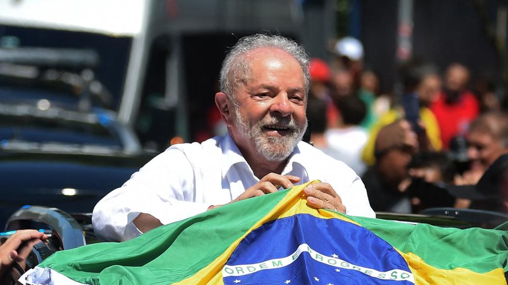 Luiz Inacio Lula da Silva holds a Brazilian flag while leaving a polling station in Sao Paolo during Sunday's presidential runoff election.