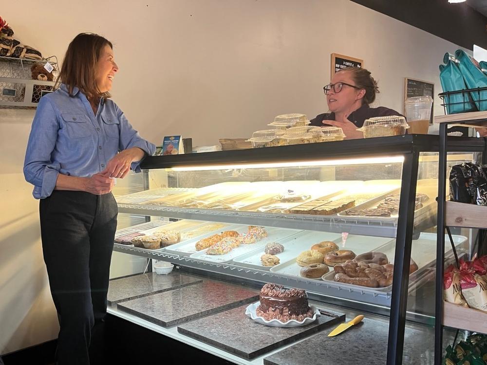 Iowa Democratic Rep. Cindy Axne speaks with barista Ali Meineke at a campaign stop in Panora, Iowa.