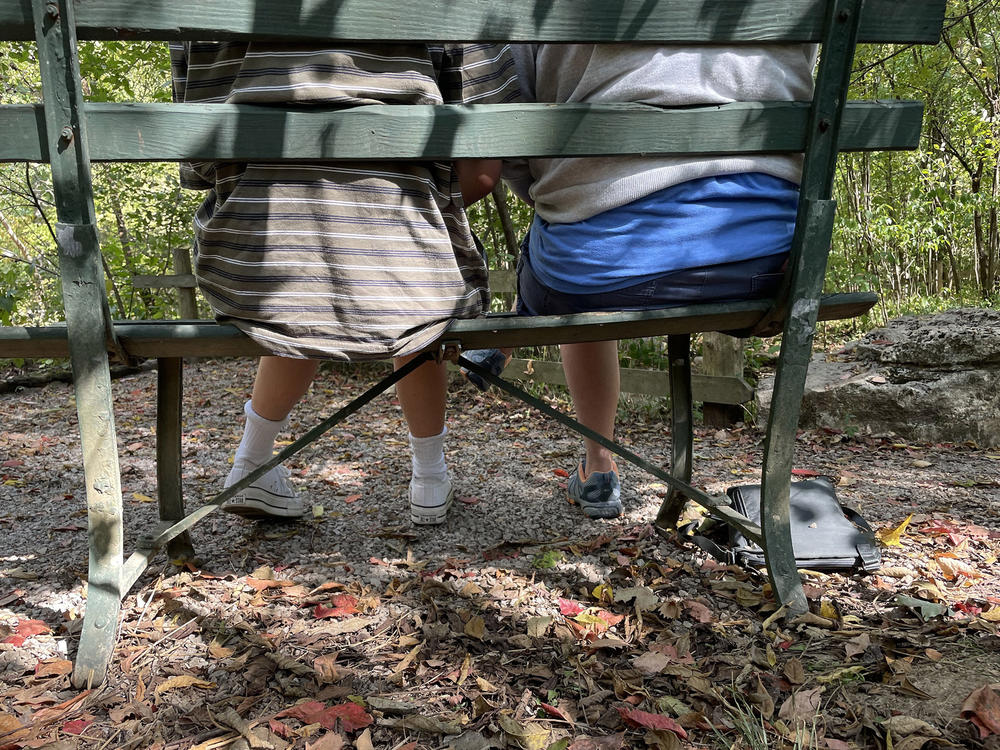 A trans teen, Adams, and his mom Elizabeth sit on a bench together in Nashville's Percy Warner Park. The 14-year-old is planning on beginning hormone treatment in the coming months.
