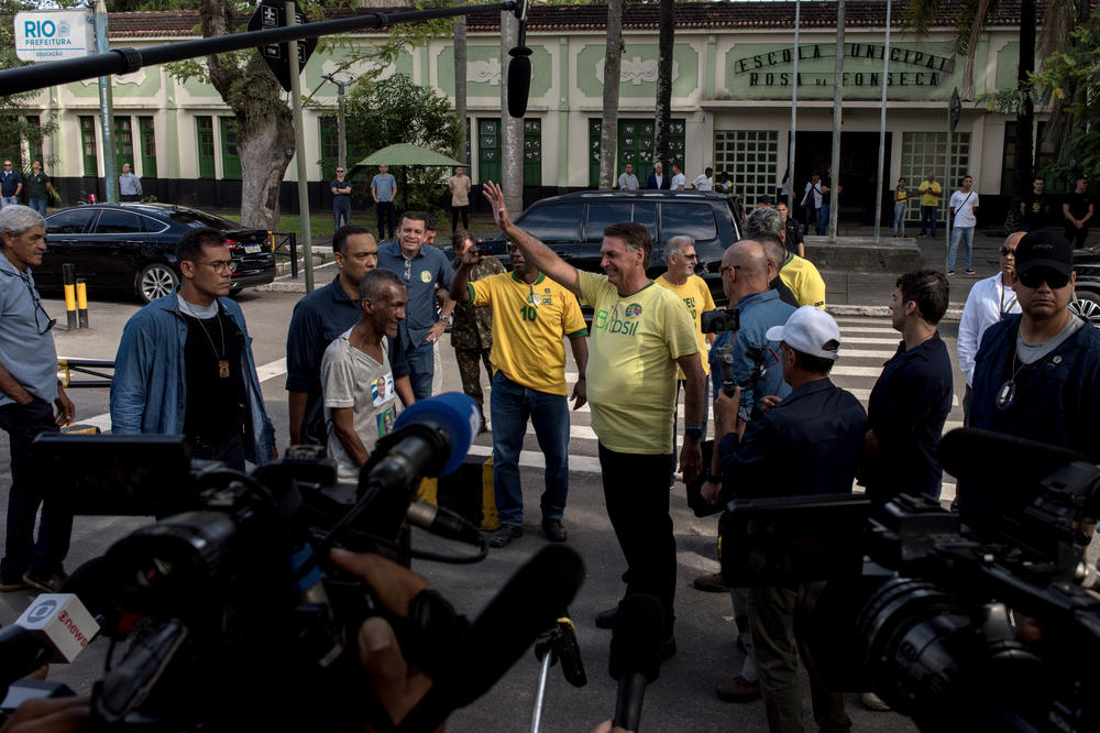 Brazilian President Jair Bolsonaro, center, speaks to members of the media outside of a polling station during the runoff presidential election in Rio de Janeiro on Sunday.