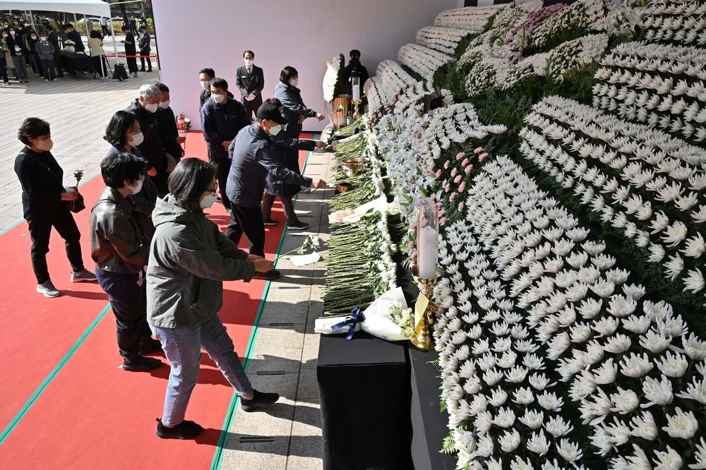 Mourners pay tribute in front of a joint memorial altar for victims of the deadly Halloween crowd surge, outside city hall in Seoul on Monday.