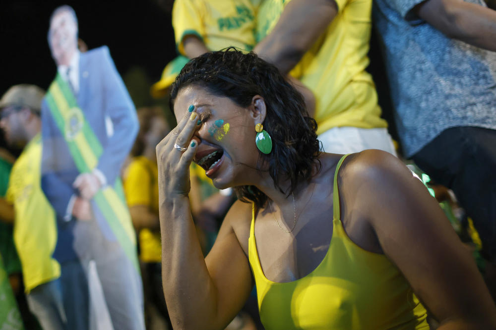 Supporters of incumbent candidate Jair Bolsonaro in Brasilia on Sunday react to the news that candidate Luiz Inácio Lula da Silva is announced as winner of the presidential runoff election.