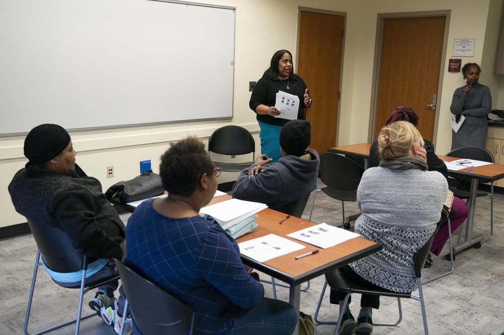 Hope Wilson, standing at center, leads a homeownership workshop on Oct. 17. She manages the housing program for the nonprofit Working in Neighborhoods, which is helping The Port's renters get in financial shape to buy a home.