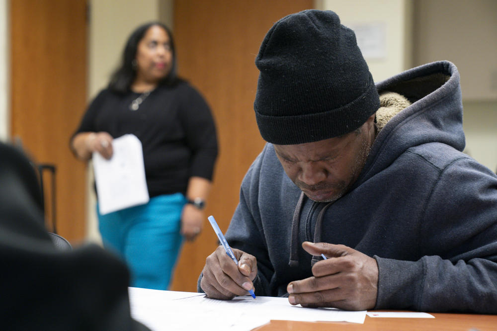 Derrick Davidson fills out a questionnaire at the homeownership workshop. He and his partner are hoping to buy the home they rent to help create generational wealth for their six children.