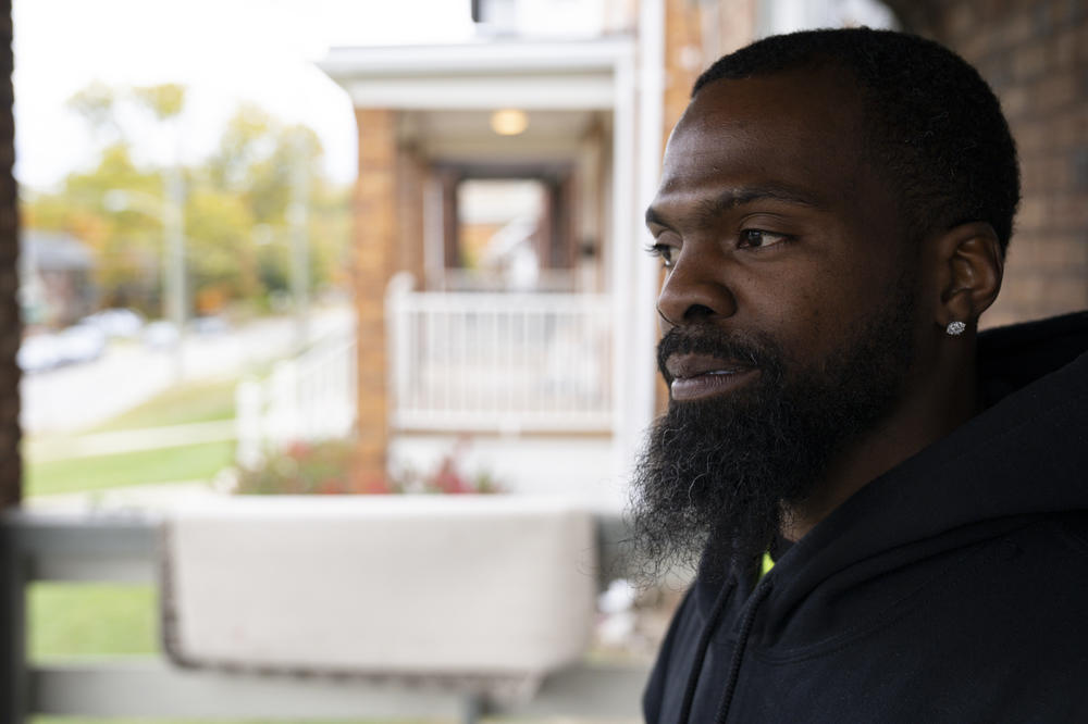 Demetrius Harper-Edwards stands on the porch of the home he's renting in Cincinnati. He and his girlfriend hope to be among the first to buy their home from the local public agency that is their new landlord.