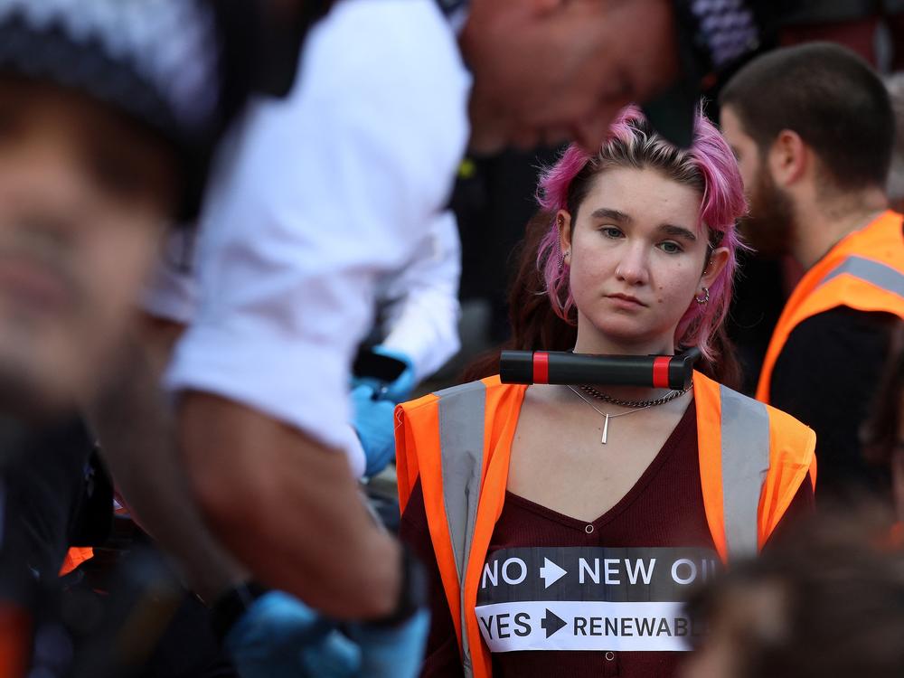 Phoebe Plummer, pictured at a demonstration in London's Piccadilly Circus in early October, spoke to <em>Morning Edition</em> about the tactics Just Stop Oil is using to draw attention to the urgency of climate change.