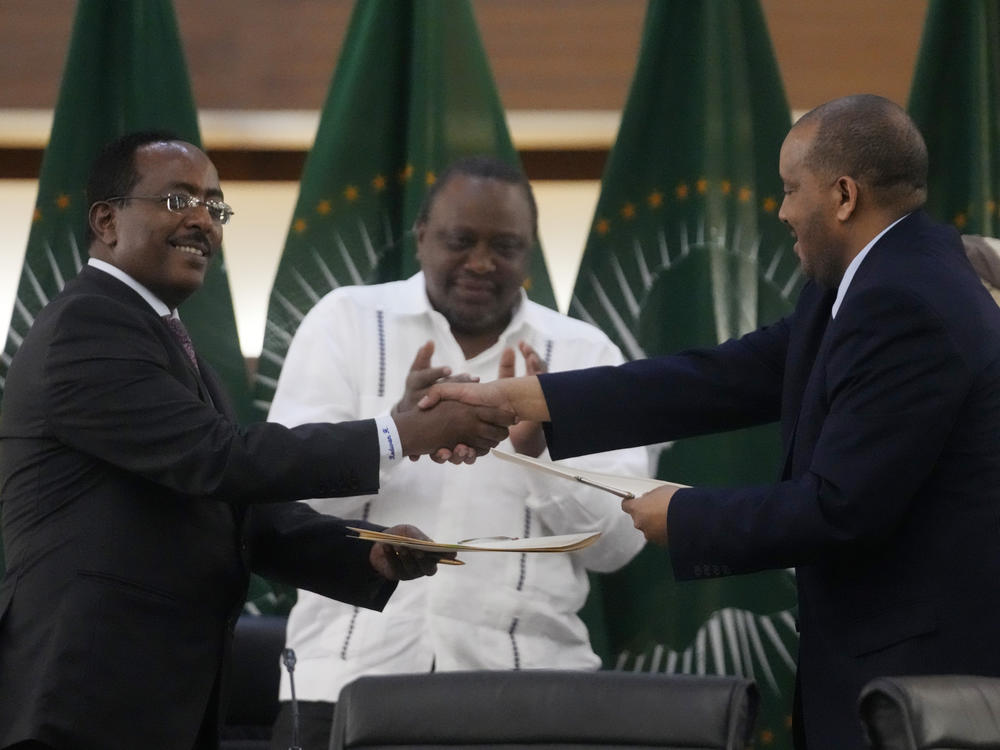 Lead negotiator for Ethiopia's government Redwan Hussein (left) shakes hands with lead Tigray negotiator Getachew Reda, as Kenya's former president, Uhuru Kenyatta looks on, after the peace talks in Pretoria, South Africa, on Wednesday.