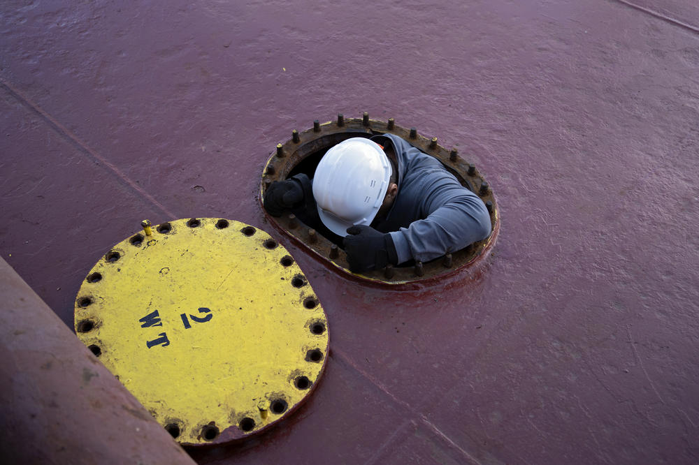 U.N. inspector Shamil Berdaliev climbs down into the ballast tank of the Tzarevich.
