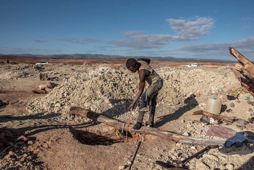 A diamond miner hauls up a bucket of gravel at an illegal mining site in South Africa's Northern Cape Province.