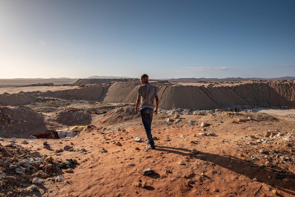 An illegal diamond miner looks out from the top of a De Beers mine that has since been taken over by zama-zamas.