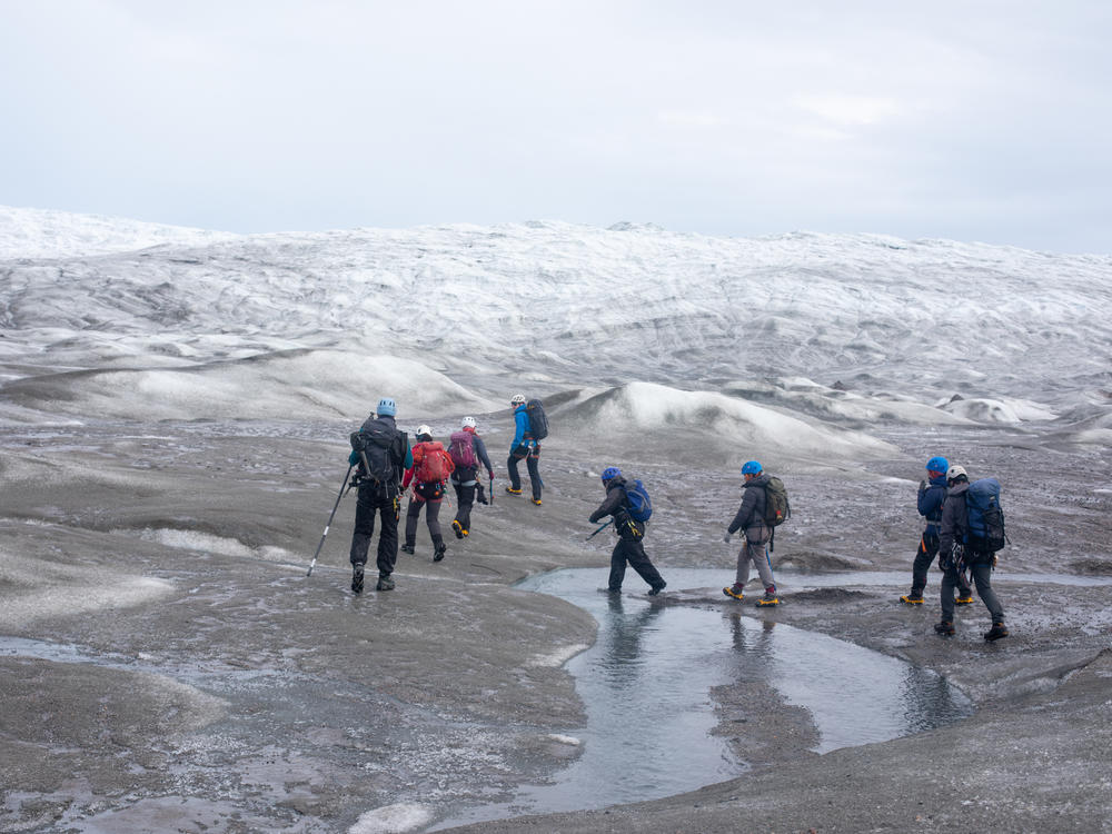 A group of scientists from the United Kingdom trek up to a research site on the west side of the Greenland ice sheet near Kangerlussuaq in the summer of 2022. This year marks the 26th year that Greenland has lost more ice than it gained.