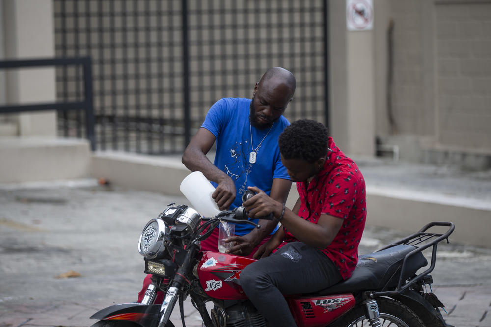 A man sells gasoline to a motorcycle driver on a street in the Pétion-Ville district of Port-au-Prince on Oct. 23.