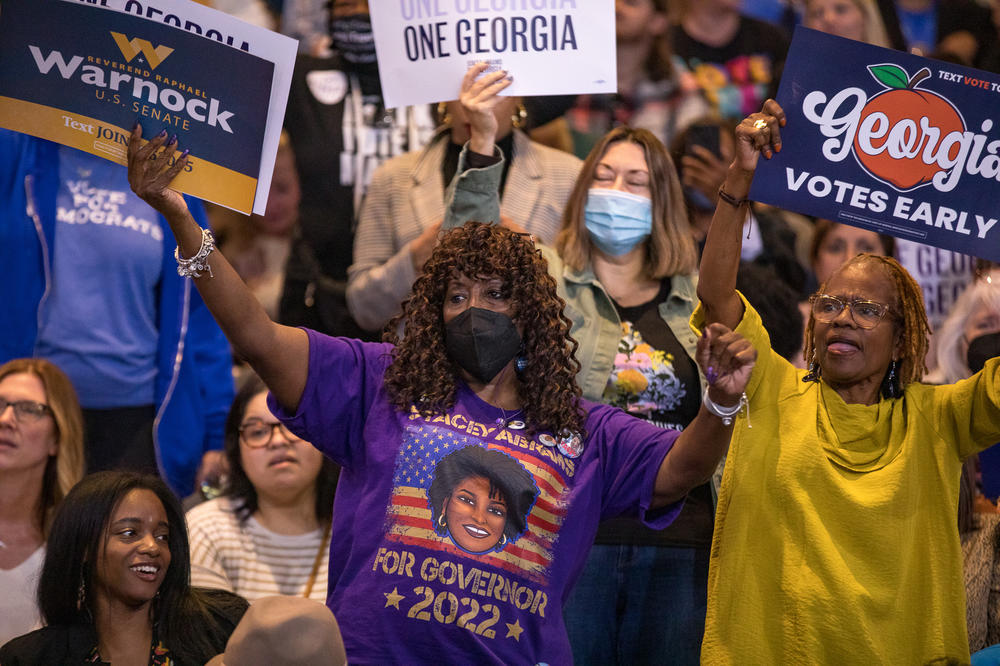 Supporters of Abrams and Warnock dance in the stands of The Gateway Center in College Park, Ga., ahead of remarks by Obama on Oct. 28.
