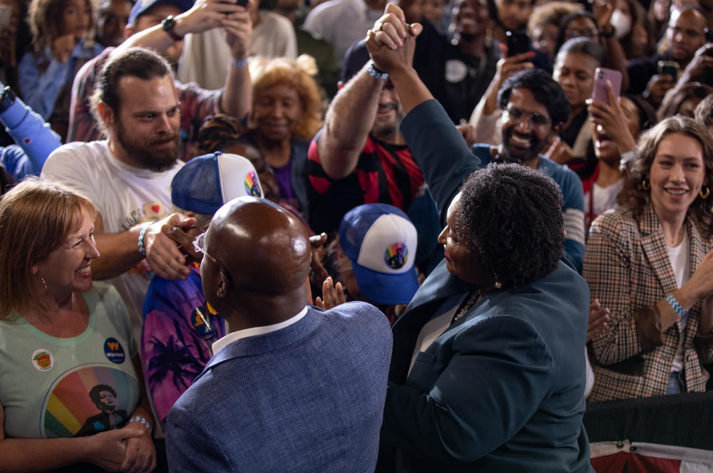 Abrams and Warnock greet supporters during a rally in College Park, Ga. on Oct. 28. <em>
