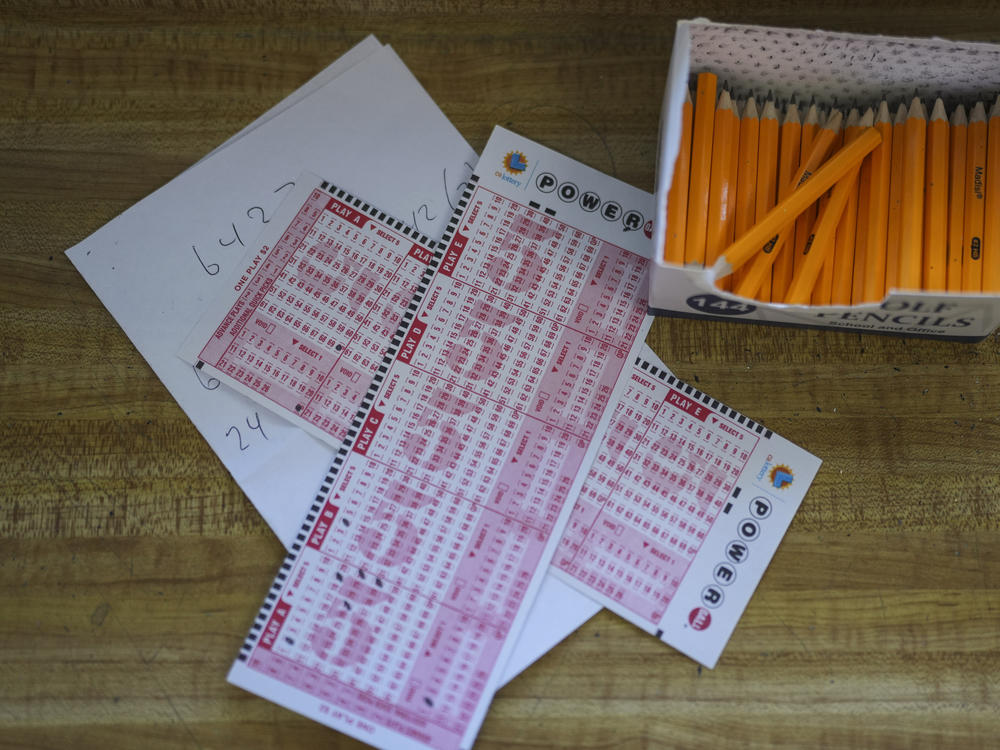 Two Powerball playslips sit on top of a piece of scratch paper at Bluebird Liquor in Hawthorne, Calif., Wednesday, Nov. 2, 2022.