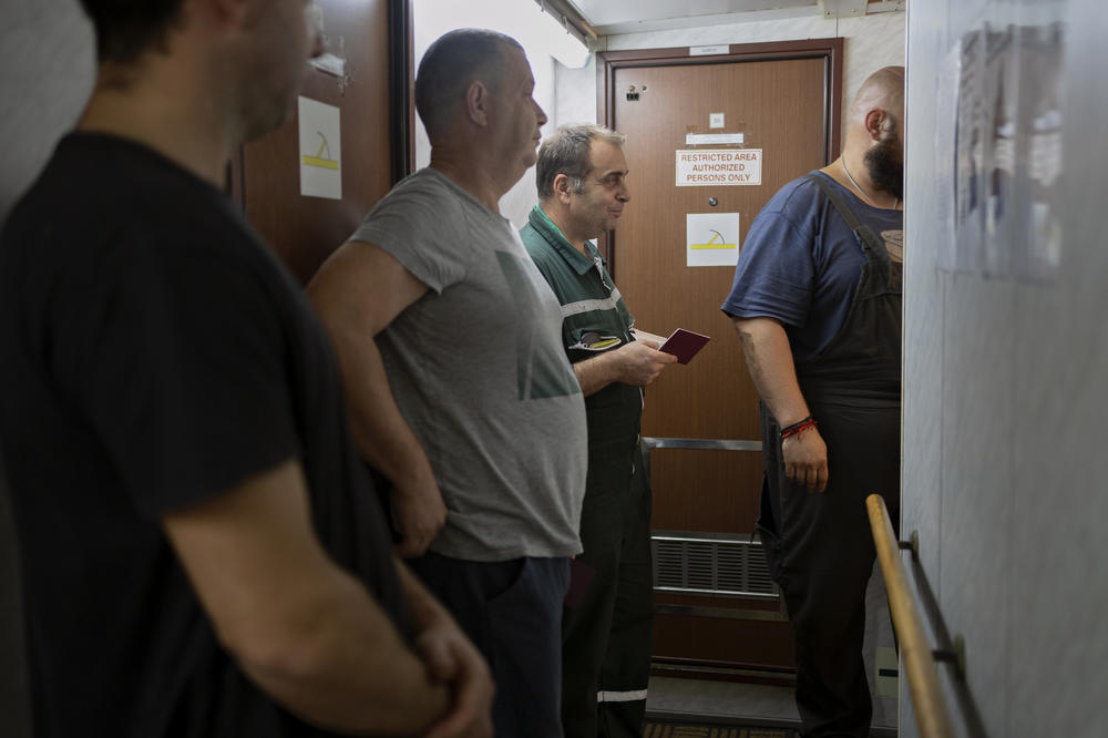 Crew members of the Tzarevich ship wait in line to get their passports verified before grain inspection can begin. The entire crew lines up in the narrow passages of the ship as a Russian inspector with a manifest checks IDs. If even the slightest detail is amiss, the ship will not be allowed to pass through until they've corrected the issue.