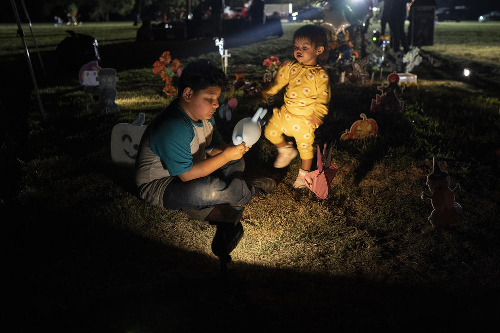 Jermya López, 8, Xavier López's brother, and his niece Katalina Mata, 1, play on top of Annabelle Rodríguez's grave on Day of the Dead.