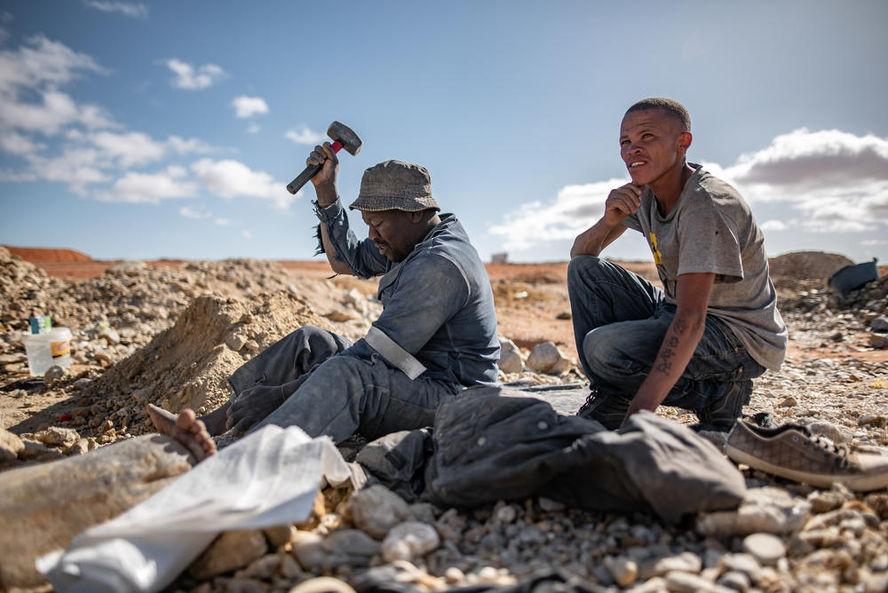 An ilegal diamond miner breaks up rocks at the Nuttabooi mine near Kleinzee, South Africa.