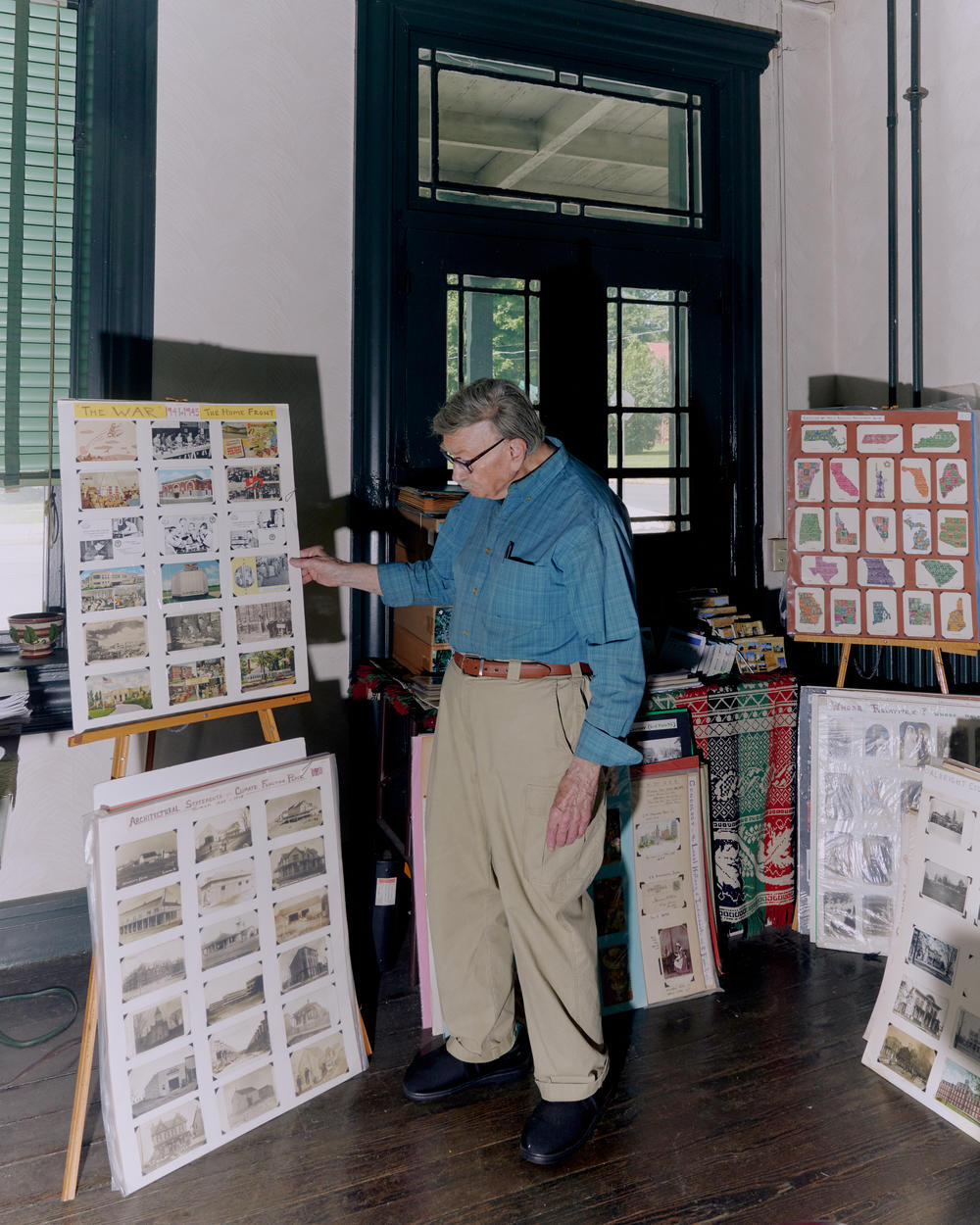 Brown stands near some of the many boards of archived postcards inside his home.