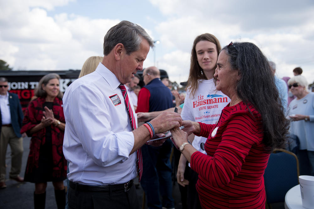 Kemp signs a flier in Marietta, Ga., on Nov. 3. He urged supporters to ignore the polls showing him ahead of Democrat Stacey Abrams. 