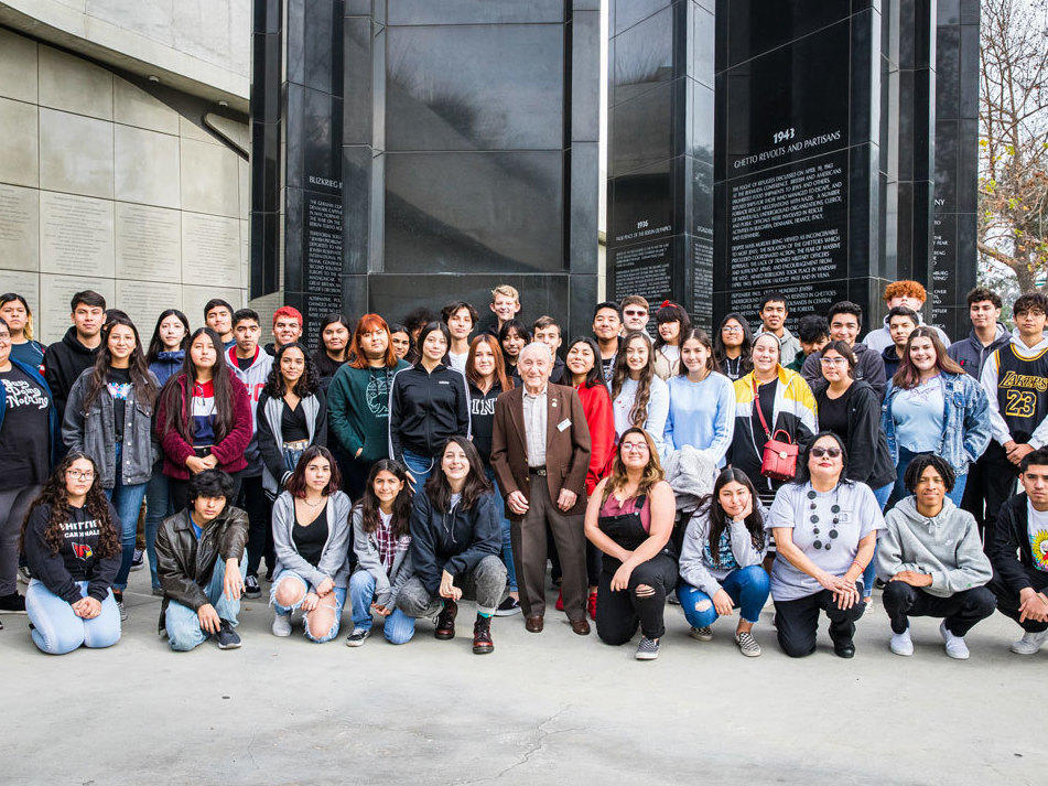 Holocaust survivor Joe Alexander, 99, poses with a group of students visiting the museum (at which he is a frequent speaker) in 2019. The museum welcomes thousands of students each year and provides bus transportation for schools.