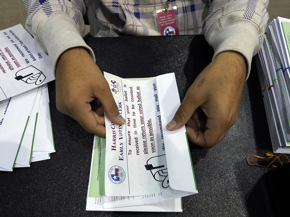 A Harris County election worker prepares mail-in ballots to be sent to Texas voters ahead of the 2020 election. After a GOP-backed law in 2021 changed rules for mail ballots, rejections spiked in this year's state primaries.