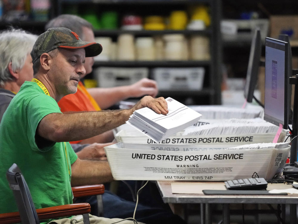 Election workers scan mail-in ballots at the Allegheny County Election Division warehouse in Pittsburgh on Thursday. The Pennsylvania Supreme Court has ordered local officials to hold off on counting ballots that arrive on time in envelopes without handwritten dates or with incorrect dates.