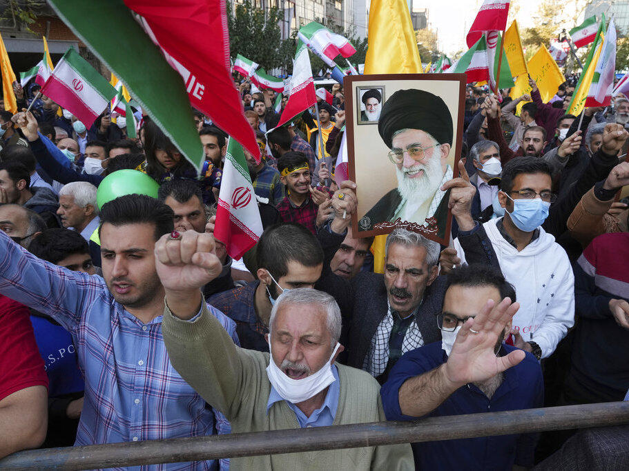 Demonstrators chant slogans Friday as one of them holds up a poster of Iranian Supreme Leader Ayatollah Ali Khamenei during a demonstration in front of the former U.S. Embassy in Tehran, Iran.