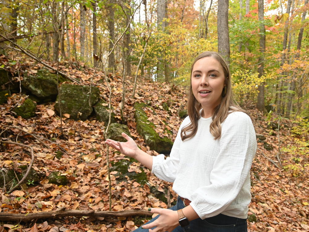 Emily Winter of Piedmont Lithium on Oct. 26, 2022 points out lithium-bearing spodumene in a rock outcrop off Whitesides Road in Bessemer City, N.C.