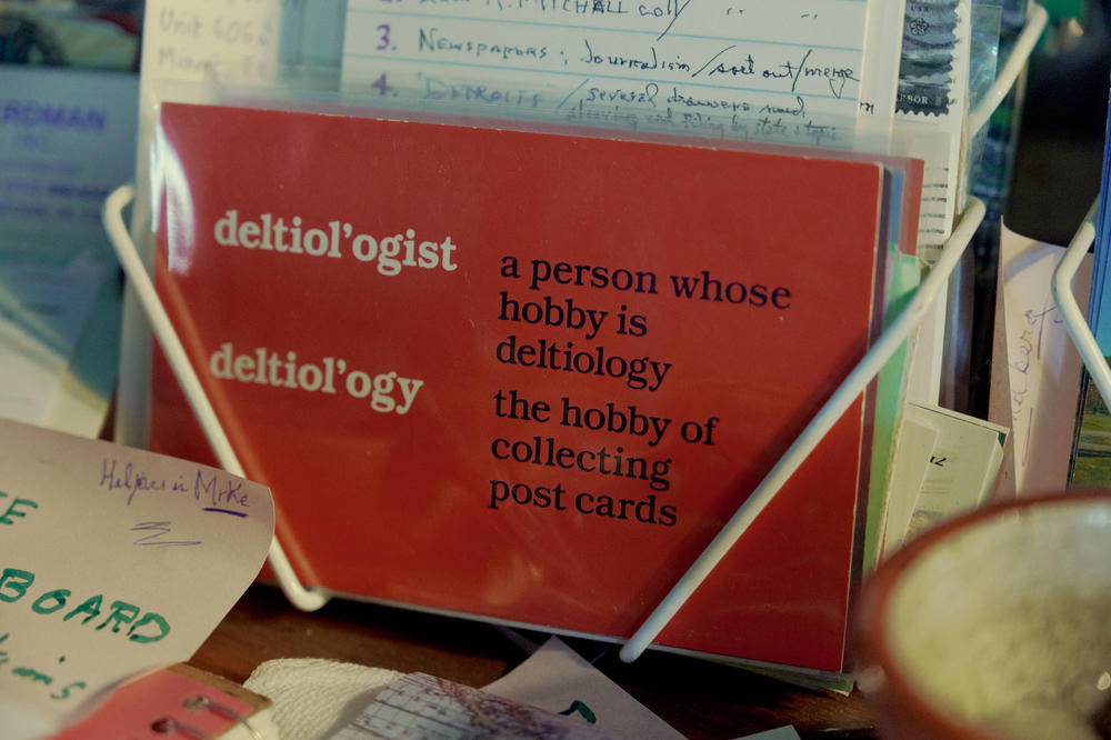 A postcard containing the definition of deltiology sits inside Brown's home.