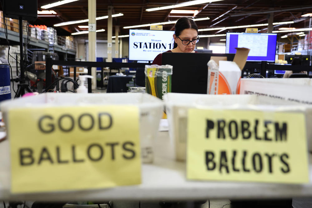 An election worker processes vote-by-mail ballots at the Orange County Registrar of Voters on Oct. 27 in Santa Ana, Calif.