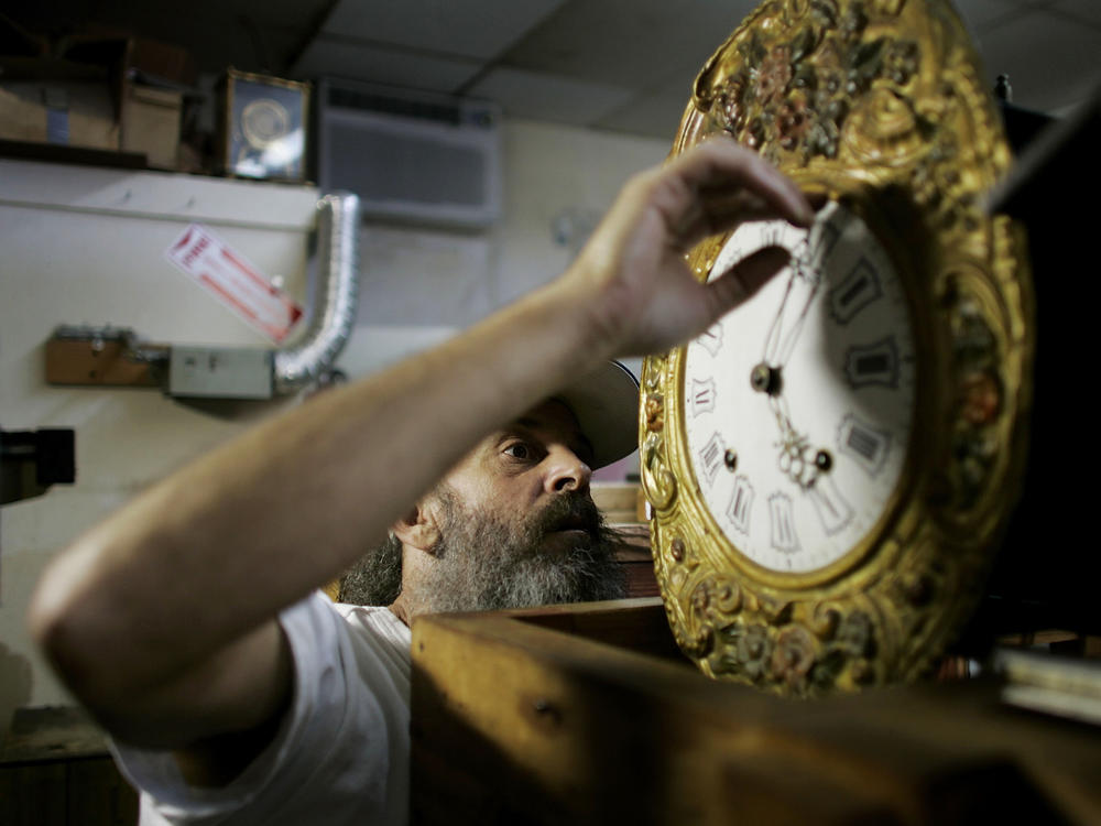 Mark Brown repairs a clock at Brown's Old Time Clock Shop in Plantation, Florida in 2007.