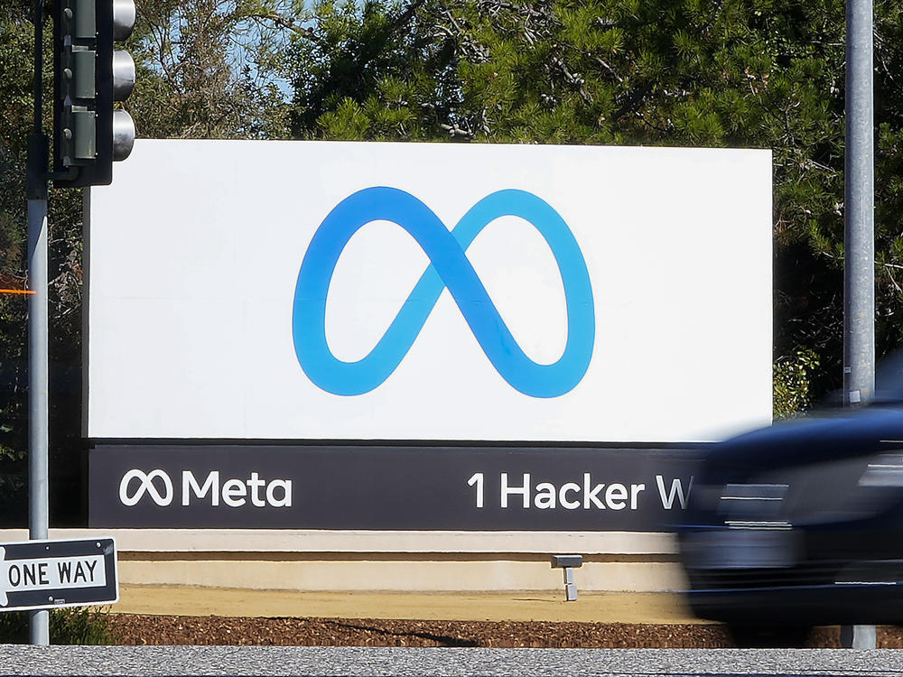 A car passes Facebook's new Meta logo on a sign at the company headquarters in Menlo Park, Calif.