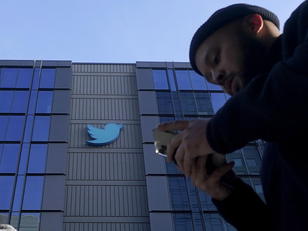 People walk outside Twitter headquarters in San Francisco, Friday, Nov. 4, 2022.