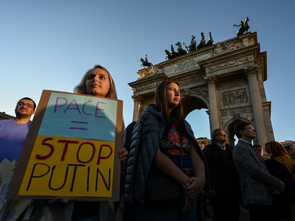 A woman holds a placard reading 