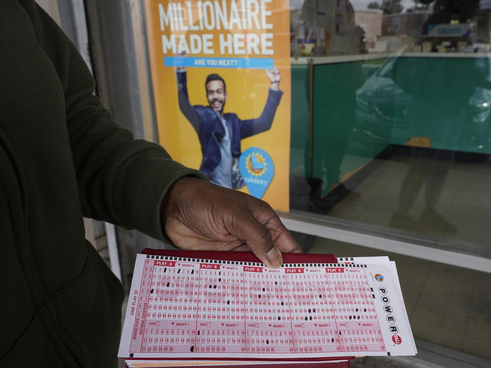A lottery player displays their Powerball picks as they wait in line to purchase tickets at Lichine's Liquor & Deli in Sacramento, Calif., Monday, Nov. 7, 2022. Monday night's drawing was at an estimated $1.9 billion.