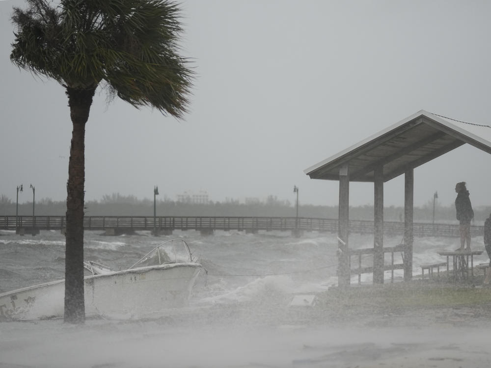 People brave rain and heavy winds to visit the waterfront along the Jensen Beach Causeway, as conditions deteriorate with the approach of Hurricane Nicole, Wednesday, Nov. 9, 2022, in Jensen Beach, Fla.