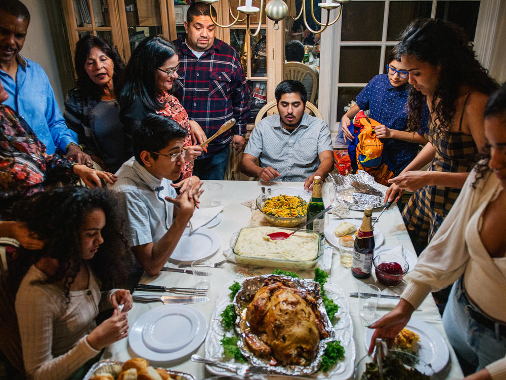 The Broughton family prepares for their dinner prayers during a gathering on November 26, 2020 in Los Angeles, California. Prices for Thanksgiving staples like turkey are on the rise this year, thanks to inflation.