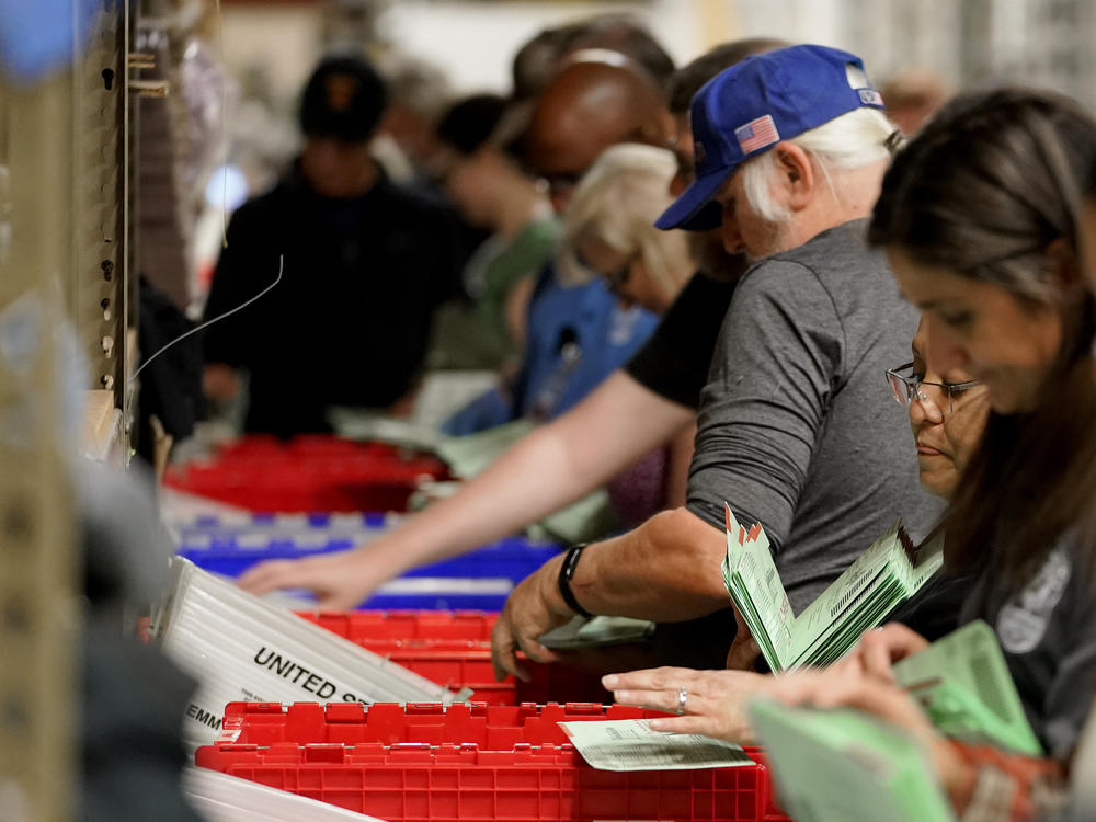 Election workers sort early ballots for signature verification prior to tabulation inside the Maricopa County recorder's office on Tuesday in Phoenix.