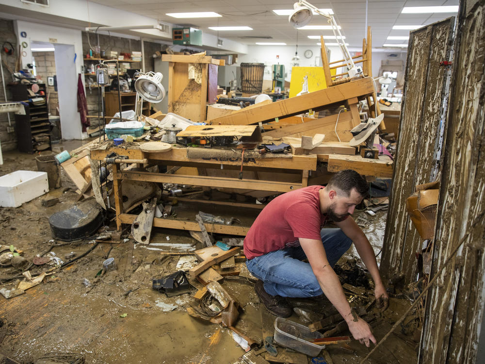 At the Appalachian School of Luthiery in Hindman, Ky., days after July's catastrophic floods, luthier Kris Patrick searches through the mud-caked remains of instruments and materials.