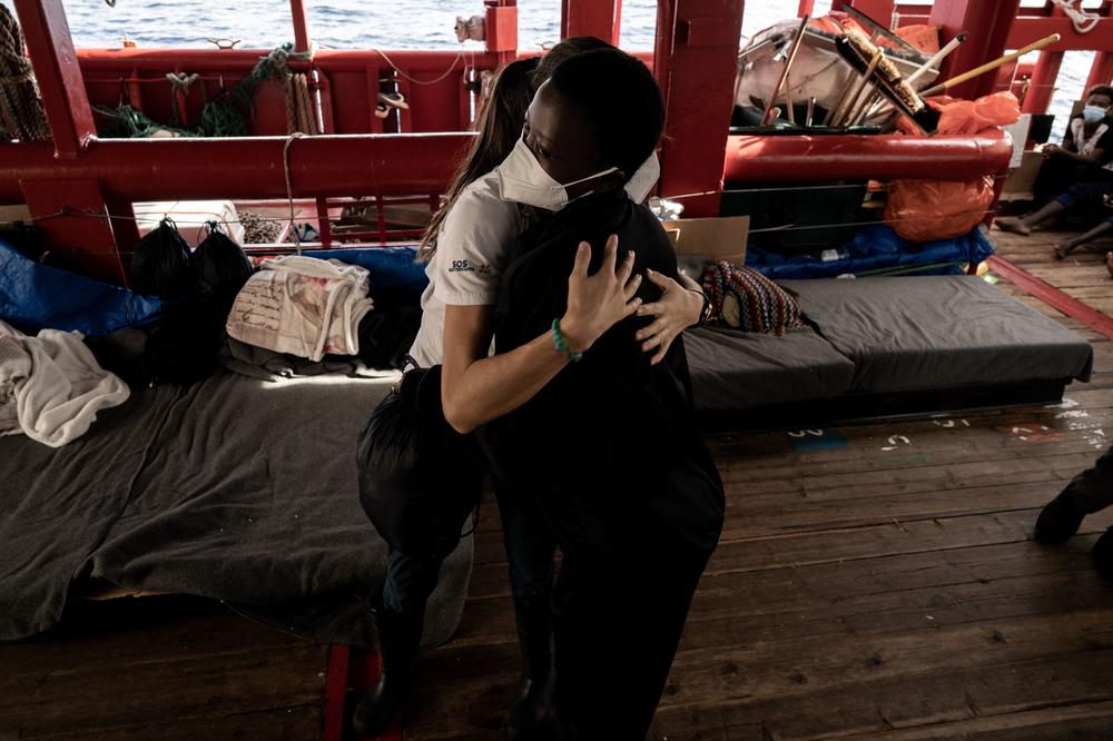 A migrant, right, embraces a volunteer before being lifted by helicopter by the French Army from the Ocean Viking rescue ship in the Tyrrhenian Sea on Thursday.