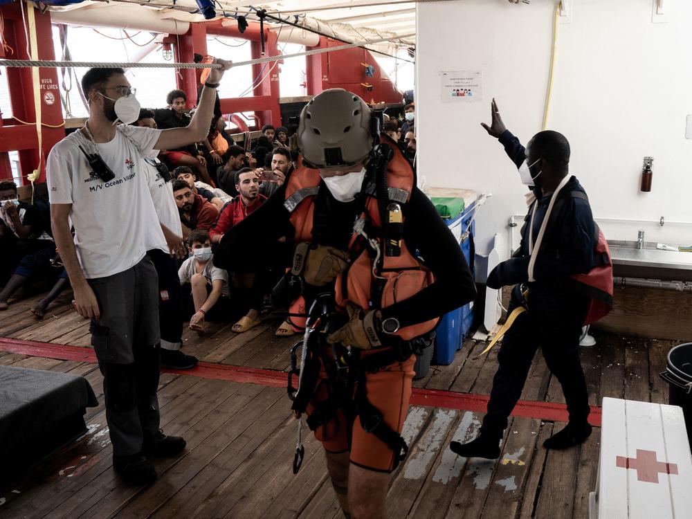A man with an arm injury and in need of urgent medical care, right, waves to fellow migrants before he is flown by helicopter by the French Army from the Ocean Viking rescue ship on Thursday. French authorities evacuated several migrants from the ship ahead of the ship docking in Toulon on Friday.