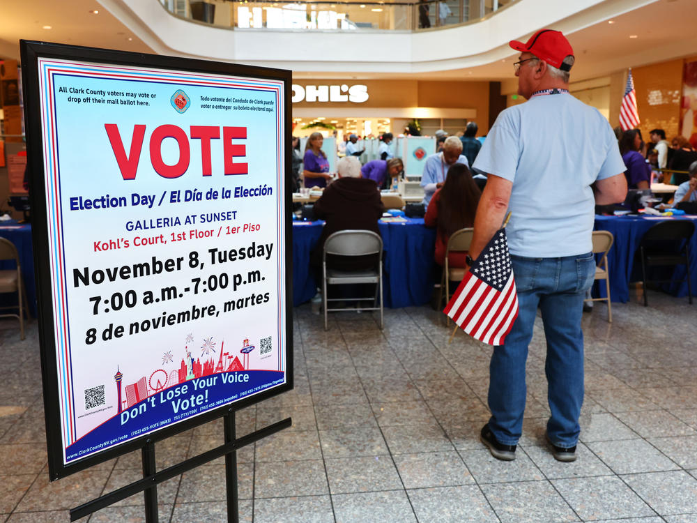 An election worker holds an American flag at a polling place at Galleria At Sunset in Henderson, Nevada on Nov. 8.