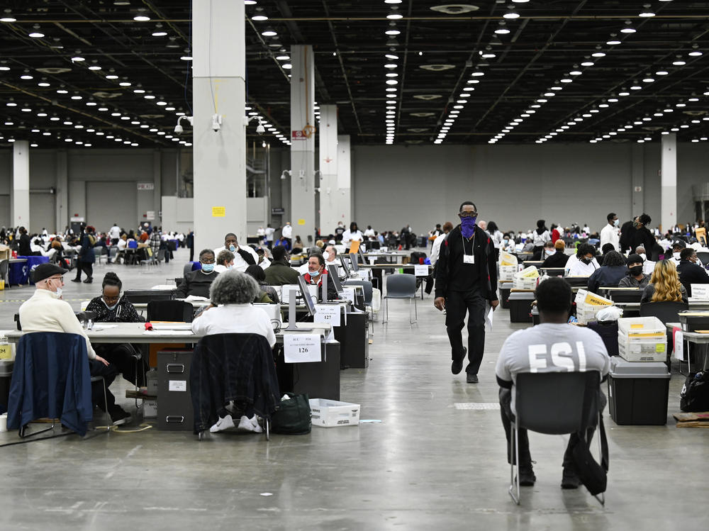 Ballot counters process absentee ballots on Nov. 8 at Huntington Place in Detroit. The scene this year was much calmer than 2020, when protesters descended on Detroit and yelled for election officials to 