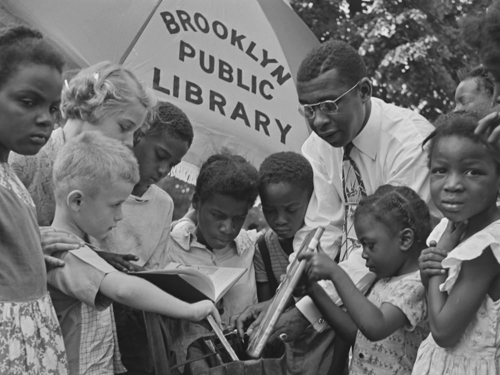 Children read outdoors at an event organized by the Brooklyn Public Library in New York City in August 1950.