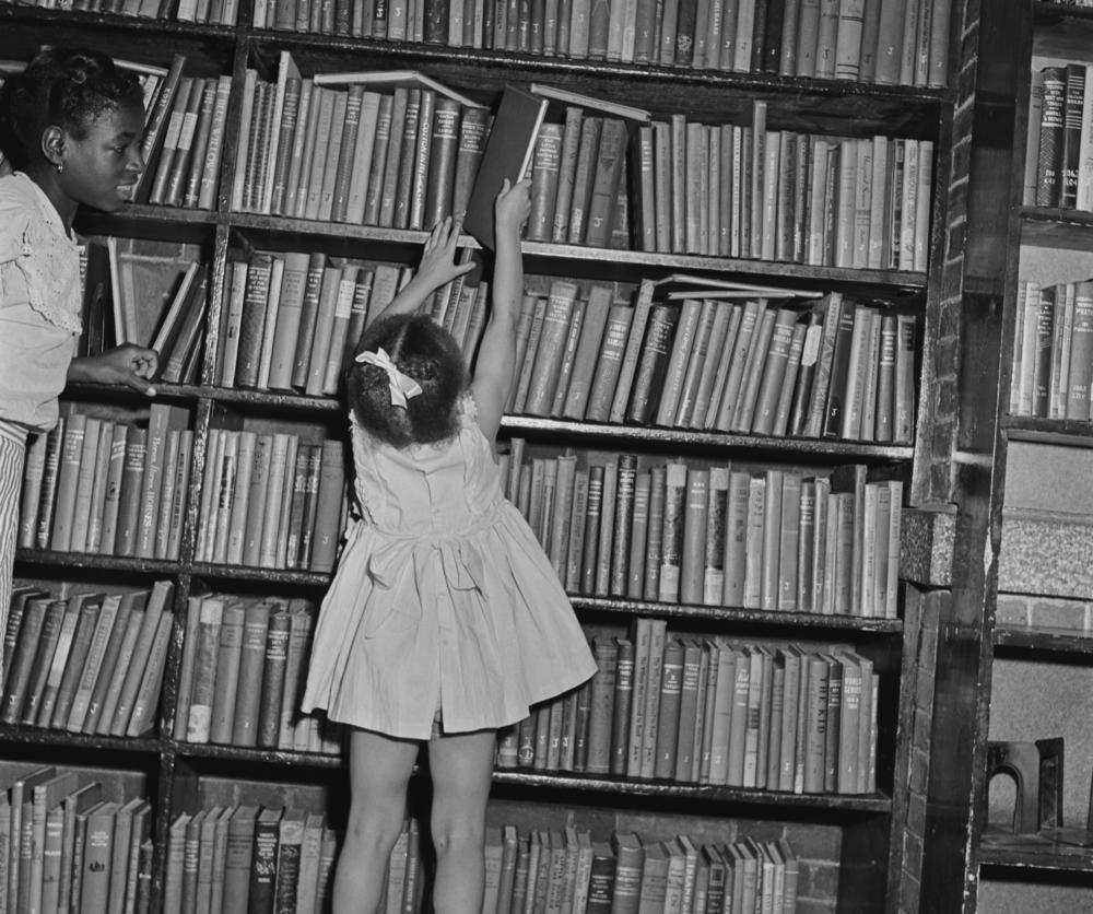 A child reaches for a book at a branch of the Brooklyn Public Library in August 1950.
