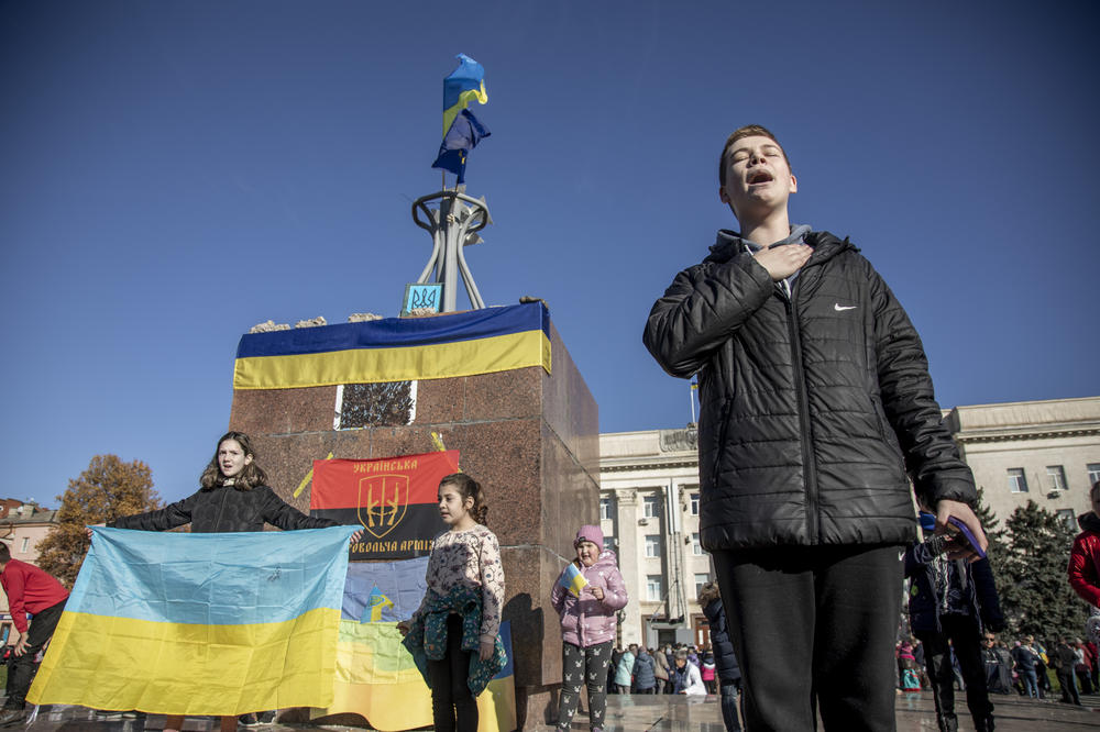 Civilians carrying Ukrainian flags celebrate the withdrawal of the Russian army at Independence Square in Kherson on Monday.