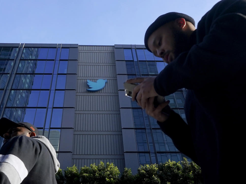 People walk outside Twitter headquarters in San Francisco, Friday, Nov. 4, 2022.